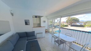 A modern apartment with a living area, a dining table, and a balcony with a view of the sea. - Studio for 2 people in the heart of Saint-Tropez (ST TROPEZ)
