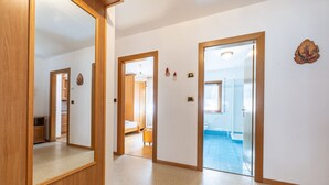 A hallway with wooden doors leading to a bedroom and bathroom. - Majon Fior de Bosch 1 (Campitello di Fassa)