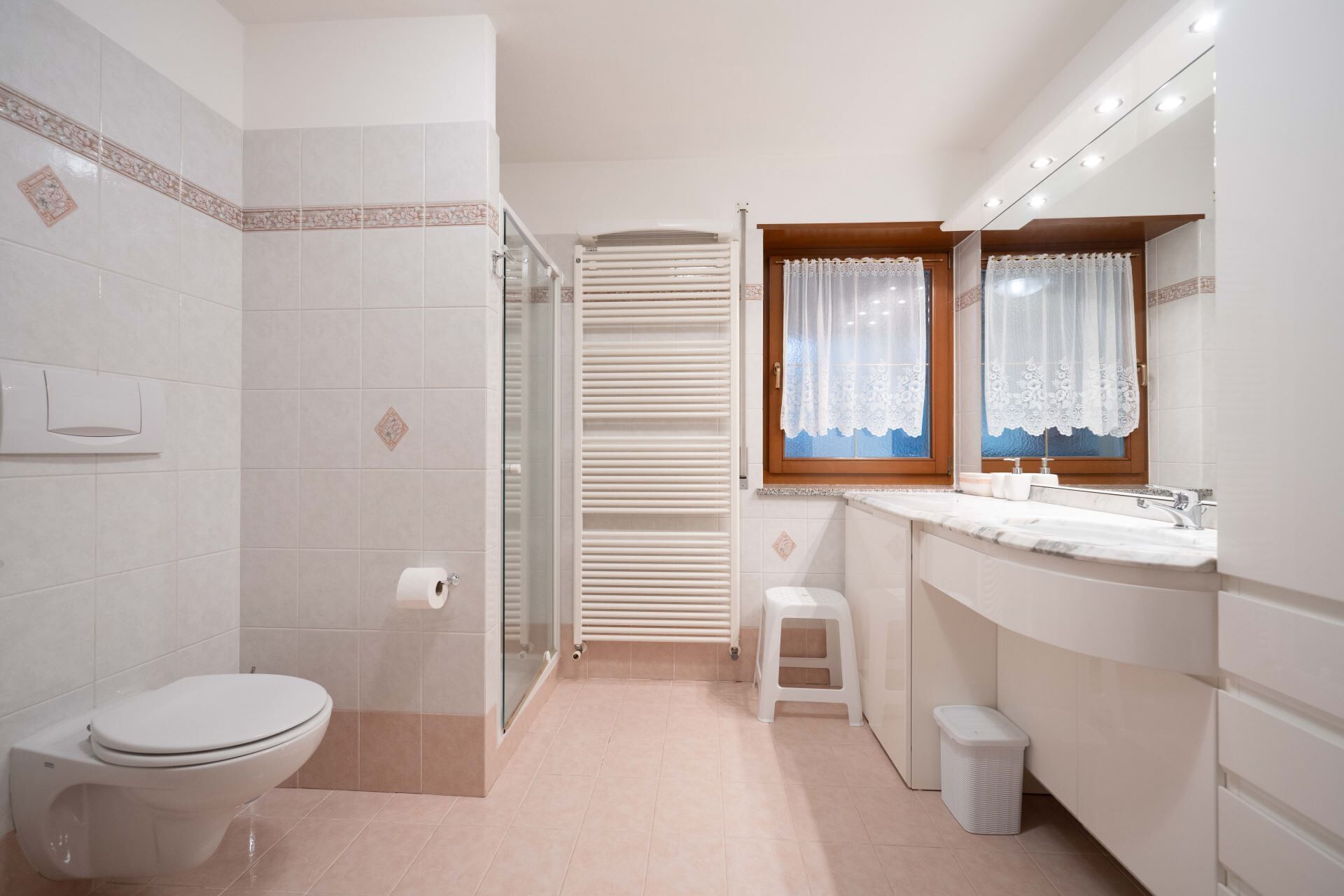 A modern bathroom with a toilet, shower, and sink area.