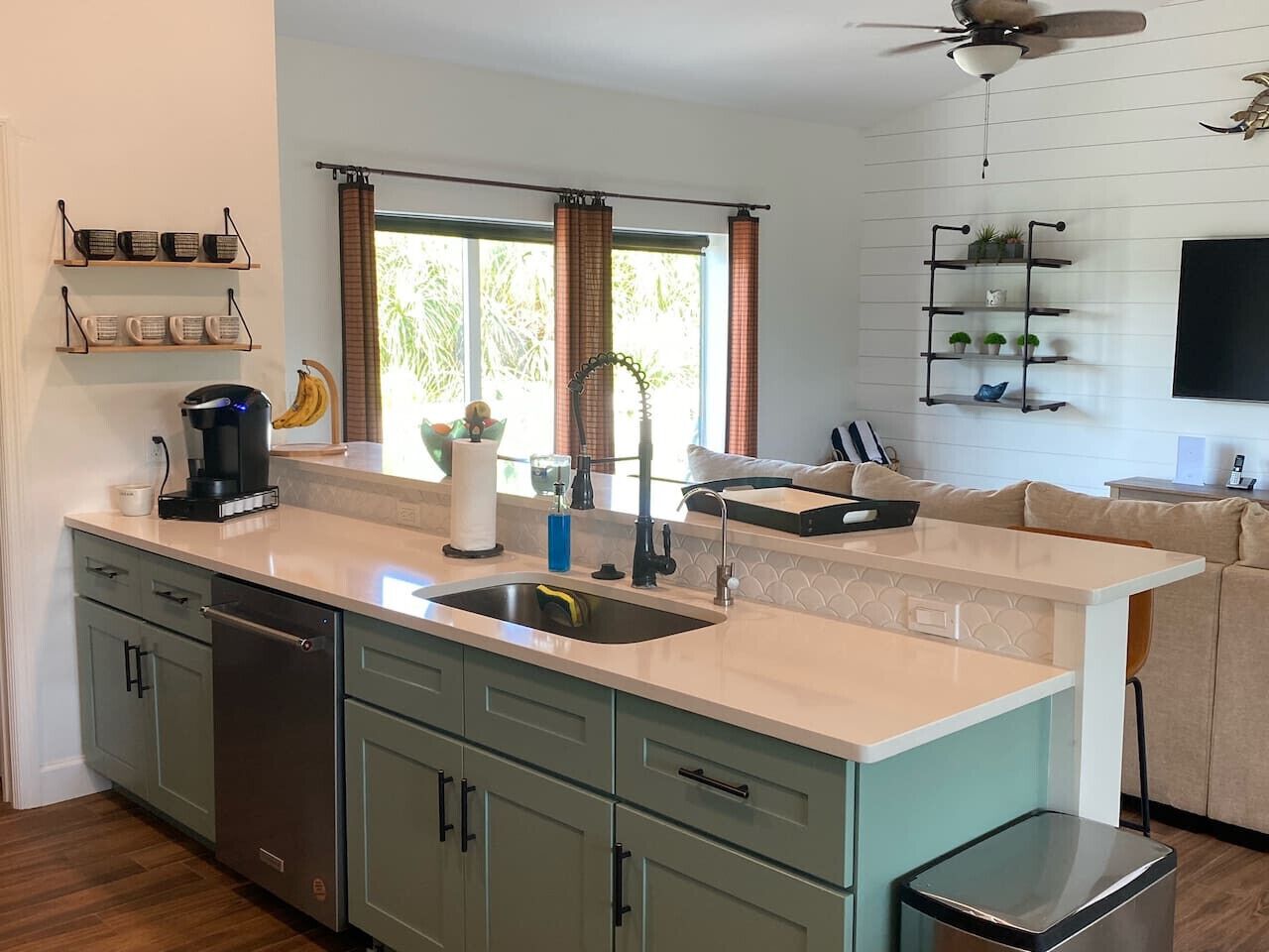 A modern kitchen with a central island, built-in appliances, and a dining area with a sofa.