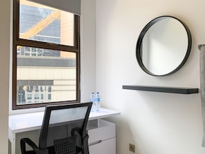 Un espace de bureau moderne comprenant un bureau, une chaise et une grande fenêtre donnant sur un chantier de construction.