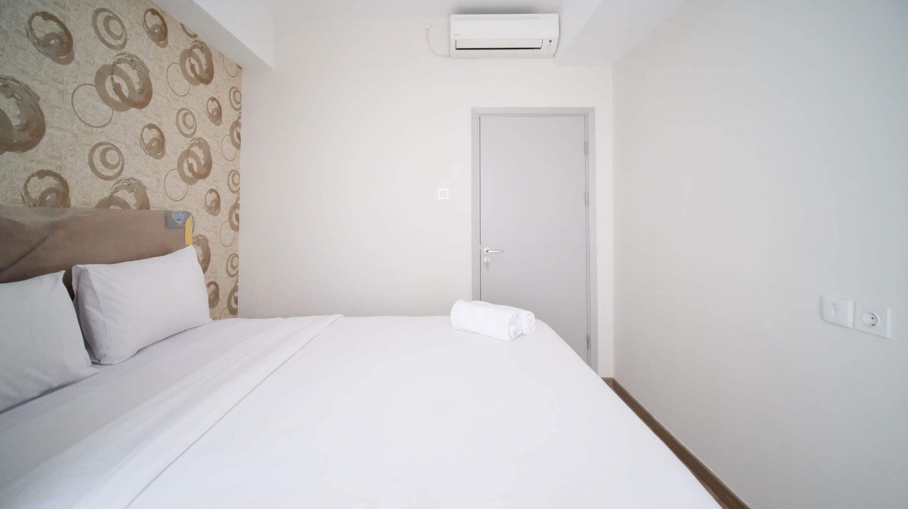 A hotel room with a bed, a door, an air conditioning unit, and a patterned wall.