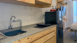 Eine Küche mit Holzausstattung, einer Granit-Arbeitsplatte, einem Edelstahlkühlschrank und einem eingebauten Ofen.