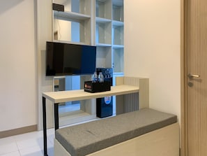 Relax in a serene space with a flat-screen TV, console table, and comfortable bench at the foot of the bed.