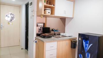 A compact kitchen with a built-in stove, a sink, and a refrigerator.