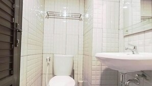 A bathroom with a white toilet, a sink, and a mirror. - Comfort Studio At De Prima Apartment (Medan)