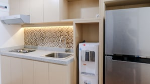 A modern kitchen with a built-in stove, sink, and stainless steel refrigerator.