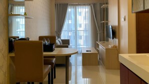 Ein modernes Hotelzimmer mit Essbereich, einer Couch, einem Fernseher und einem Badezimmer.