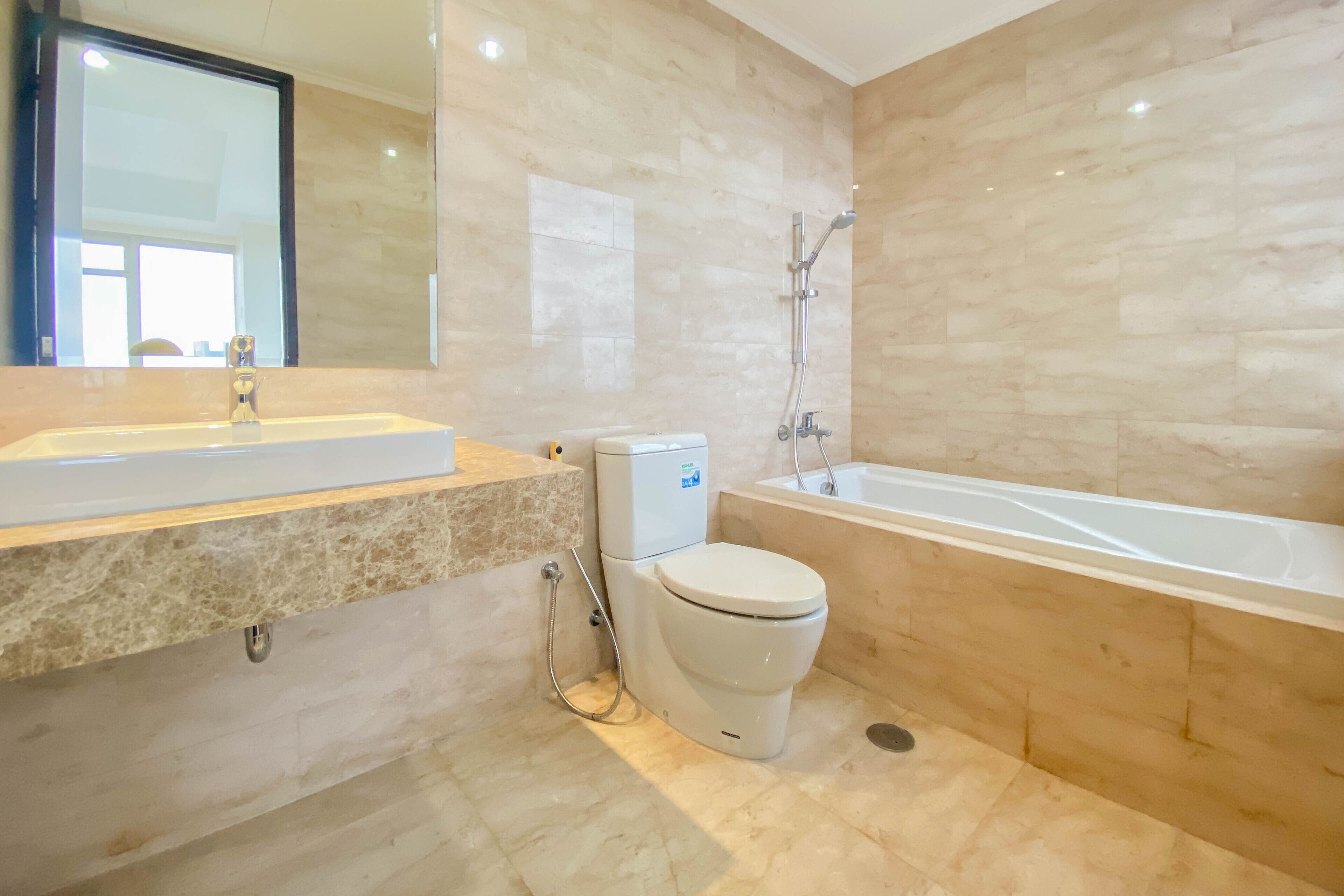 A modern bathroom with a sink, toilet, and bathtub.