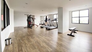 Un gimnasio amplio con cintas de correr, máquinas de pesas y una banca.