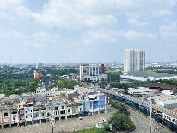 A cityscape with a mix of commercial and residential buildings, a prominent high-rise building, and a bridge.