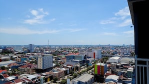 A cityscape with various buildings, including a mix of residential and commercial structures. - Relaxing Studio At Vida View Makassar Apartment (Makassar)