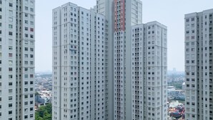A high-rise residential building with multiple floors, featuring a central core and uniform window patterns. - Nice Designed And Elegant 2Br At Green Bay Pluit Apartment (Jakarta)
