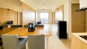 Une chambre d’hôtel moderne comprenant un coin repas, un canapé, une télévision et un coin cuisine.