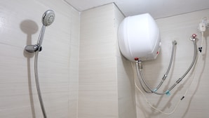 Ducha con cabezal de ducha de mano y calentador de agua instalado en la pared.