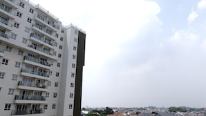 Un rascacielos con múltiples balcones y una vista despejada del paisaje urbano circundante.
