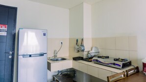 A compact kitchen with a refrigerator, sink, stove, and basic utensils. - Fancy And Nice 1Br At Paramount Skyline Apartment (Gading Serpong)