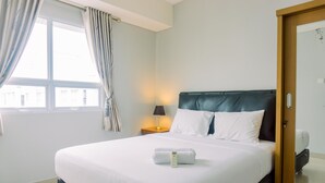 A neatly made bed with white linens, a remote control, and a towel on the bed. - Fancy And Nice 1Br At Paramount Skyline Apartment (Gading Serpong)
