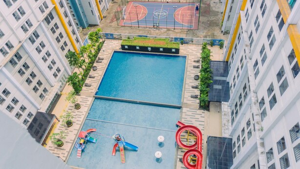 An aerial view of a residential building with a swimming pool, a basketball court, and a children's play area. - Fancy And Nice 1Br At Paramount Skyline Apartment (Gading Serpong)