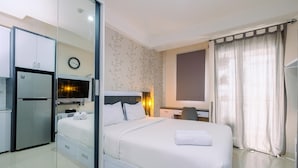 Una habitación de hotel con cama, escritorio, armario y espejo.