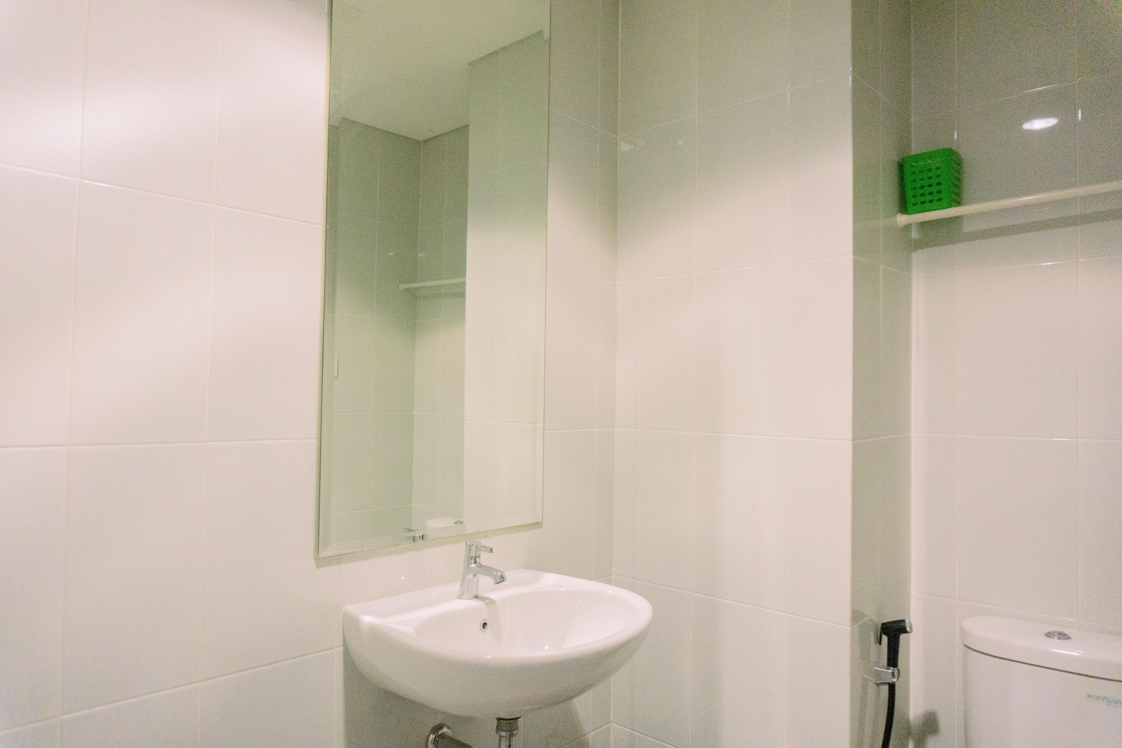 A bathroom with a white sink, a mirror, and a toilet.