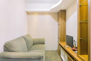 Quarto moderno com sofá, suporte de TV de madeira e guarda-roupa embutido.