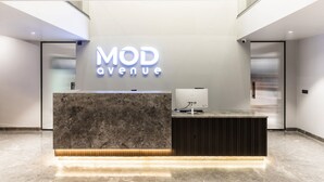 Un mostrador de recepción con encimera de mármol y diseño moderno, que muestra un letrero que dice "MOD Avenue".