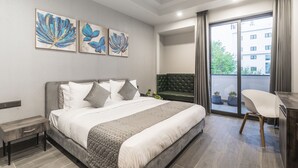 Un dormitorio moderno con cama, escritorio y vistas al exterior.