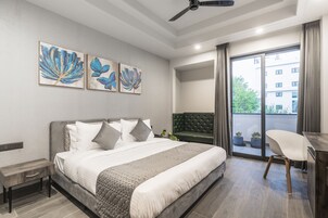 Un dormitorio moderno con cama, escritorio y vistas al exterior.