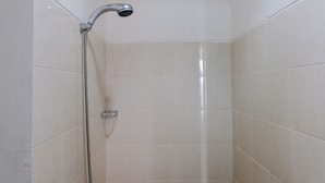 A small, tiled shower stall with a handheld showerhead and a handheld shower attachment. - Best Deal Studio at Harvard Jatinangor Apartment (Cileunyi)