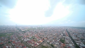A cityscape with a mix of residential and commercial buildings, roads, and green spaces. - Nice And Comfy Studio At Grand Dharmahusada Lagoon Apartment (Surabaya)
