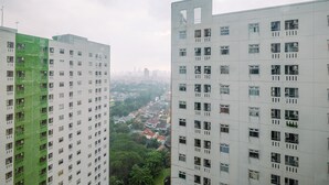 A high-rise building with multiple floors, each featuring numerous windows and balconies. - Best Deal And Modern 1Br Green Pramuka City Apartment (Jakarta)