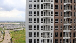 Um edifício residencial alto com várias varandas, janelas amplas e vista para o horizonte da cidade.