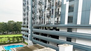 Un edificio residencial de varios pisos con balcones, piscina y jardines.