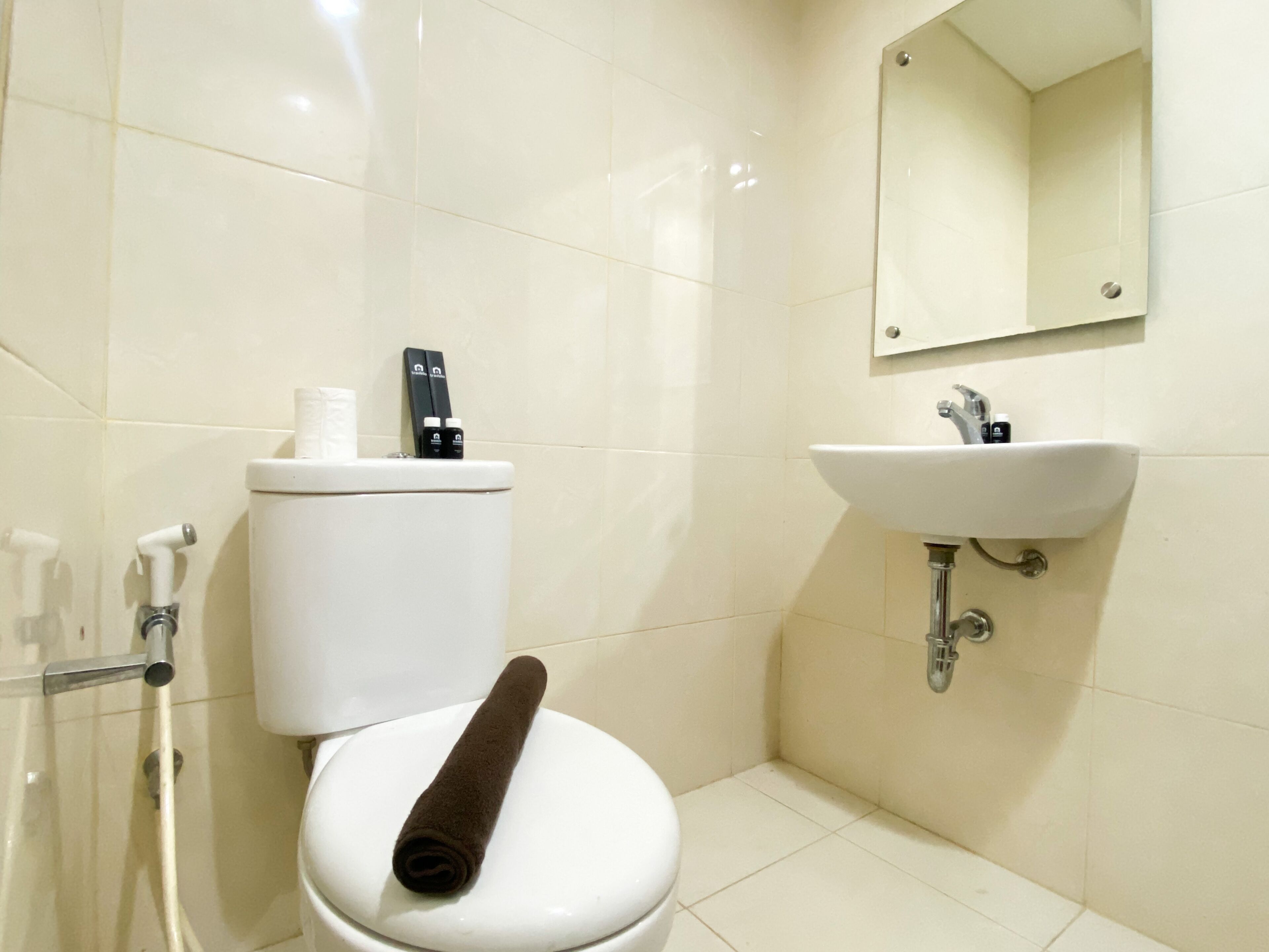 Un bagno con il water, un lavandino e uno specchio.