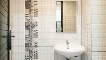 A bathroom with a shower, a sink, and a mirror.
