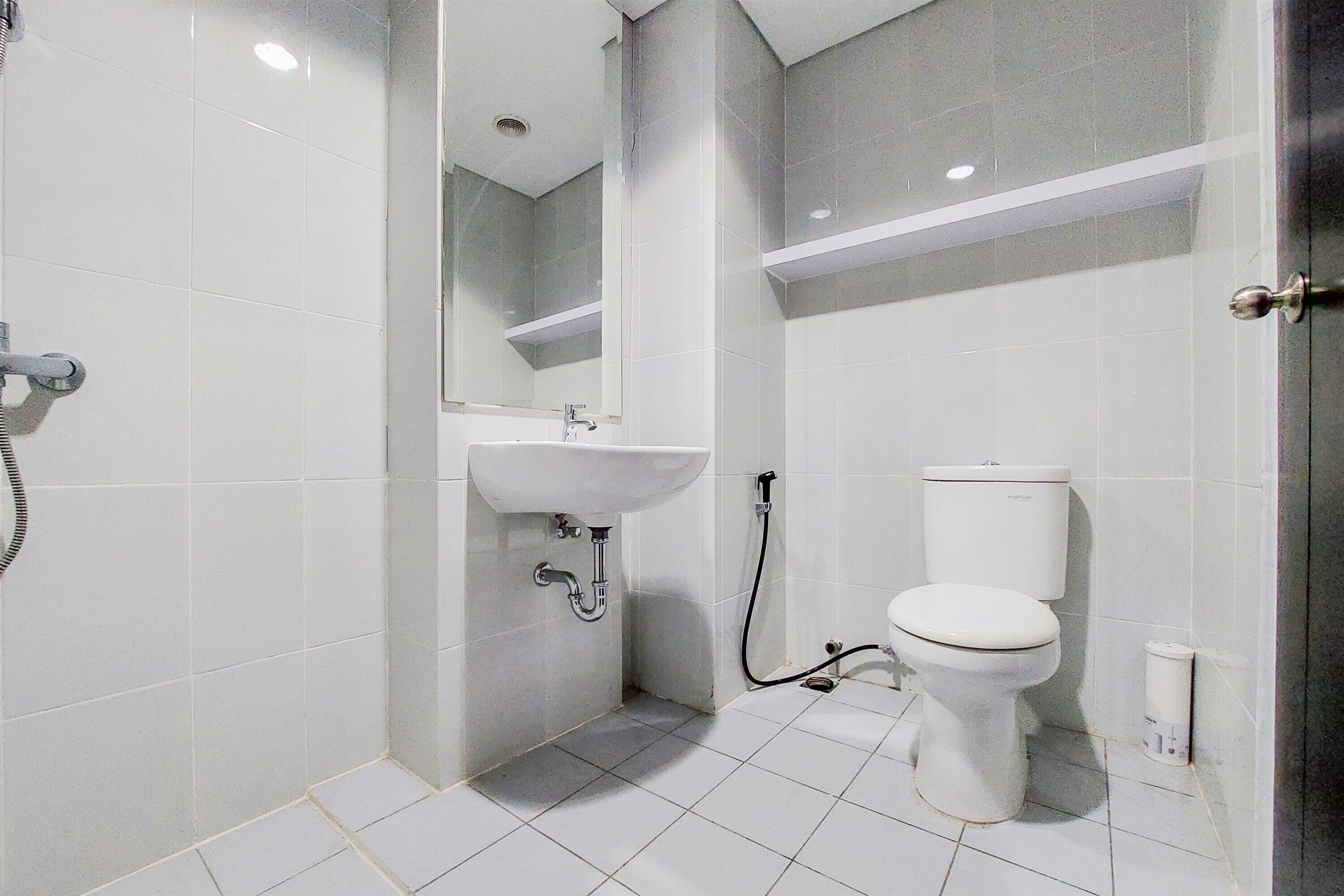 A small, modern bathroom with a toilet, sink, and shower.