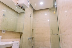 Ein modernes Badezimmer mit einer Duschkabine aus Glas, einer Toilette und einem Waschbecken.