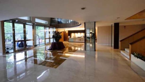 Un hall d’entrée spacieux, doté d’un comptoir de réception, de grandes fenêtres et d’un design moderne.