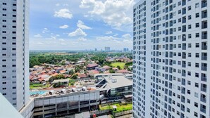 A high-rise building with a view of a residential area below. - Homey And Warm Studio Room Serpong Garden Apartment (Cisauk)
