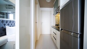 Et moderne køkken med et rustfrit stål køleskab, indbygget ovn og et flisebeklædt backsplash.