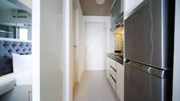 A modern kitchen with a stainless steel refrigerator, a built-in oven, and a tiled backsplash.