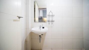 A bathroom with a white sink, a mirror, and a towel rack.