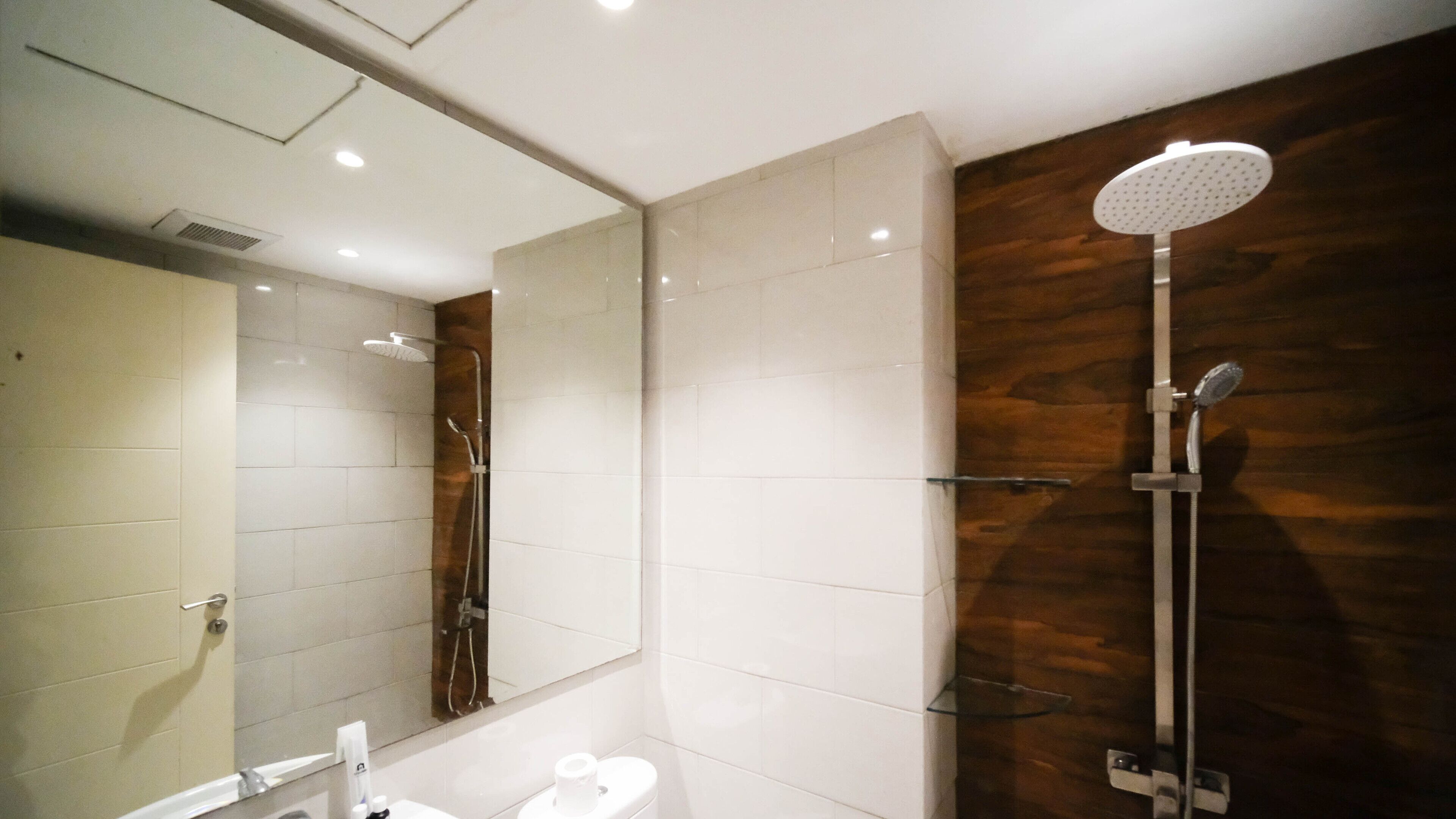Et moderne badeværelse med bruser, toilet og vask.