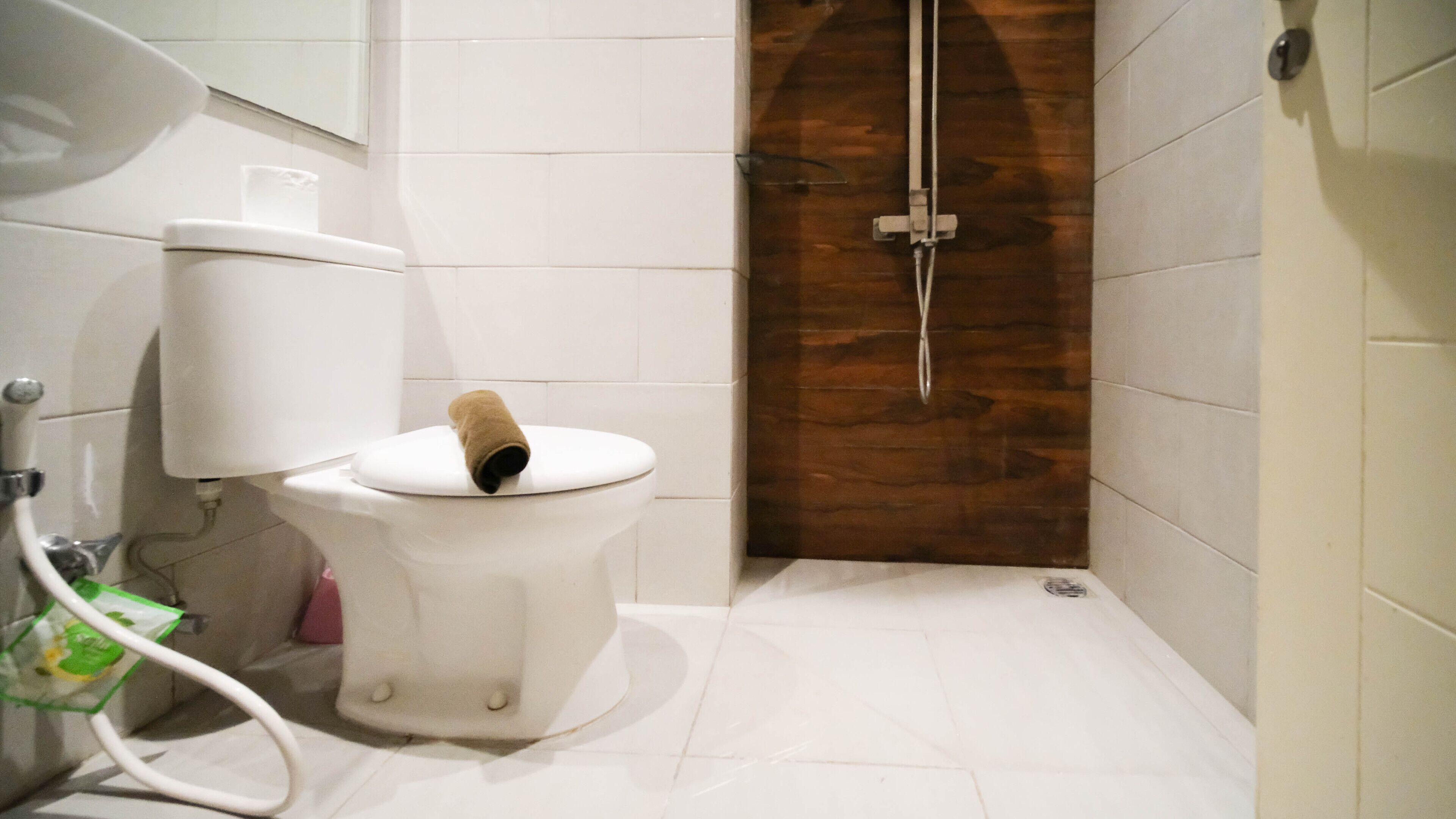 A bathroom with a toilet, a shower, and a sink.