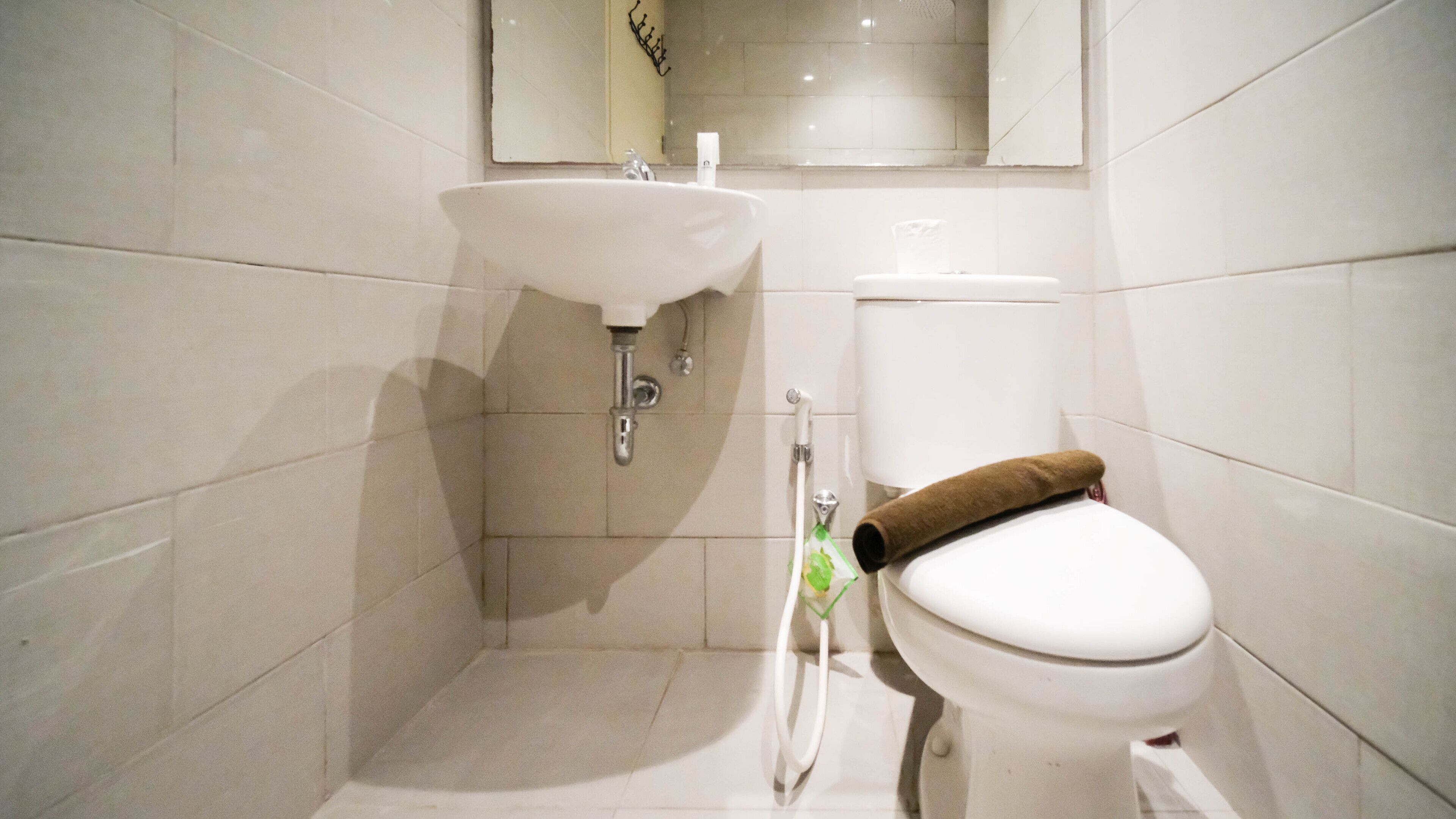 A bathroom with a white sink, toilet, and a shower area.