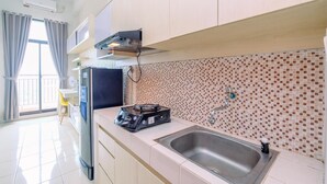 Una cocina moderna con estufa a gas, lavamanos y salpicadero de azulejos.
