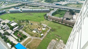An aerial view of a modern building complex with multiple structures, including a large central building, smaller adjacent buildings, and a landscaped area with a pool. - Best Deal And Comfy Studio Vasanta Innopark Apartment (Cikarang)