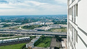 A high-rise building with a view of a highway and surrounding urban landscape. - Best Deal And Comfy Studio Vasanta Innopark Apartment (Cikarang)