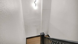Eine Treppe mit hölzernem Geländer und einer Wandleuchte.